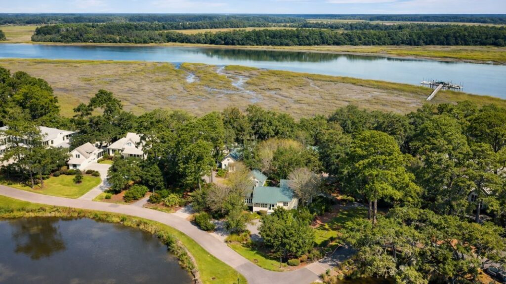 Aerial view of several homes surrounded by water in Okatie, SC, showcasing the residential area and scenic landscape.